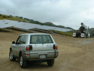 Toyota RAV4-EV plug-in car in front of 200 kW solar array it helped install